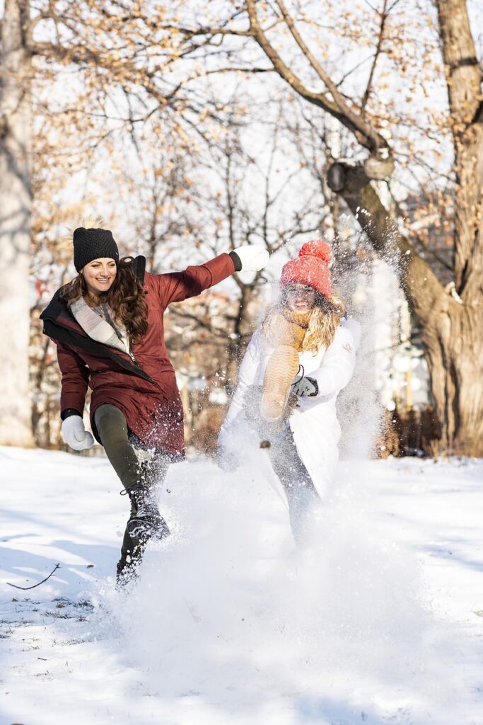 dos mujeres jugando en la nieve