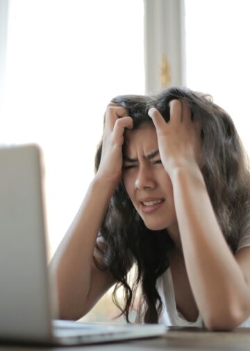 Frustrated woman struggling with remote work stress and digital challenges indoors.