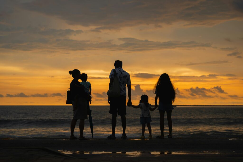 A family enjoying a serene sunset by the ocean at Colombo beach, Sri Lanka.